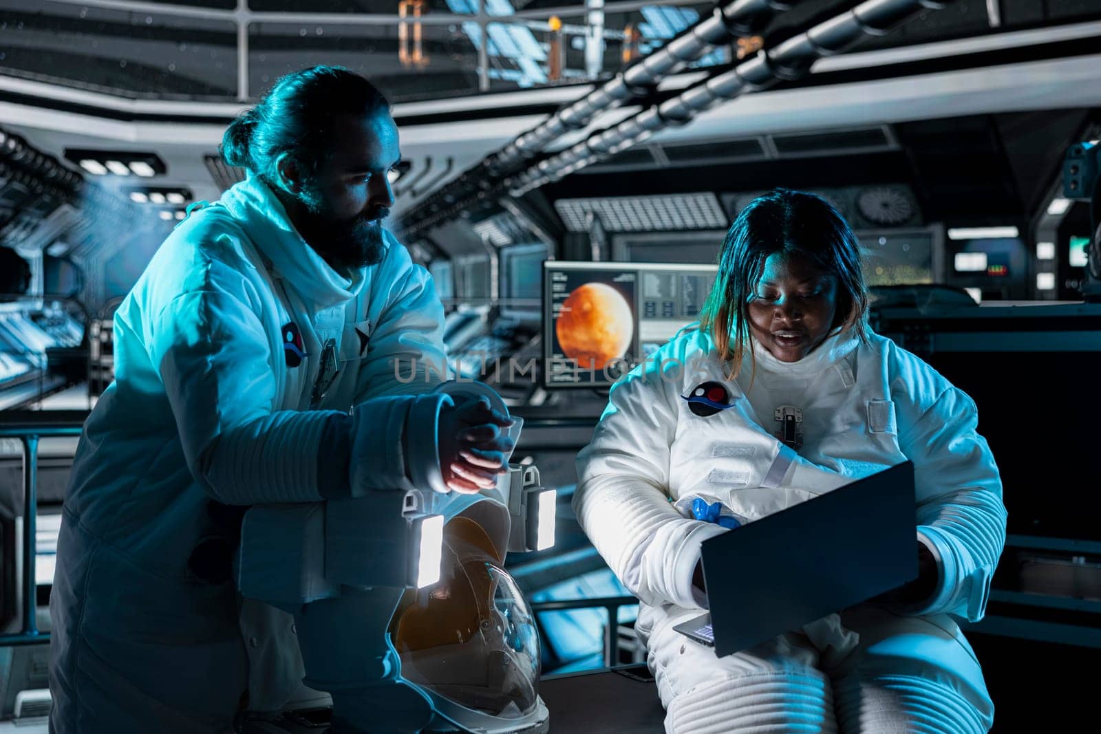 Teamworking astronauts use tablet to ensure safe operation during long distance space travel to Mars. Orbital station crew monitors system stability during cosmic journey to red planets