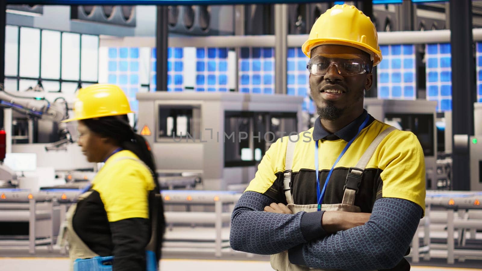 Portrait of technician overseeing solar panel production lines equipment. African American man maintaining photovoltaic assembly systems in automated industry 4.0 factory using computer, camera A