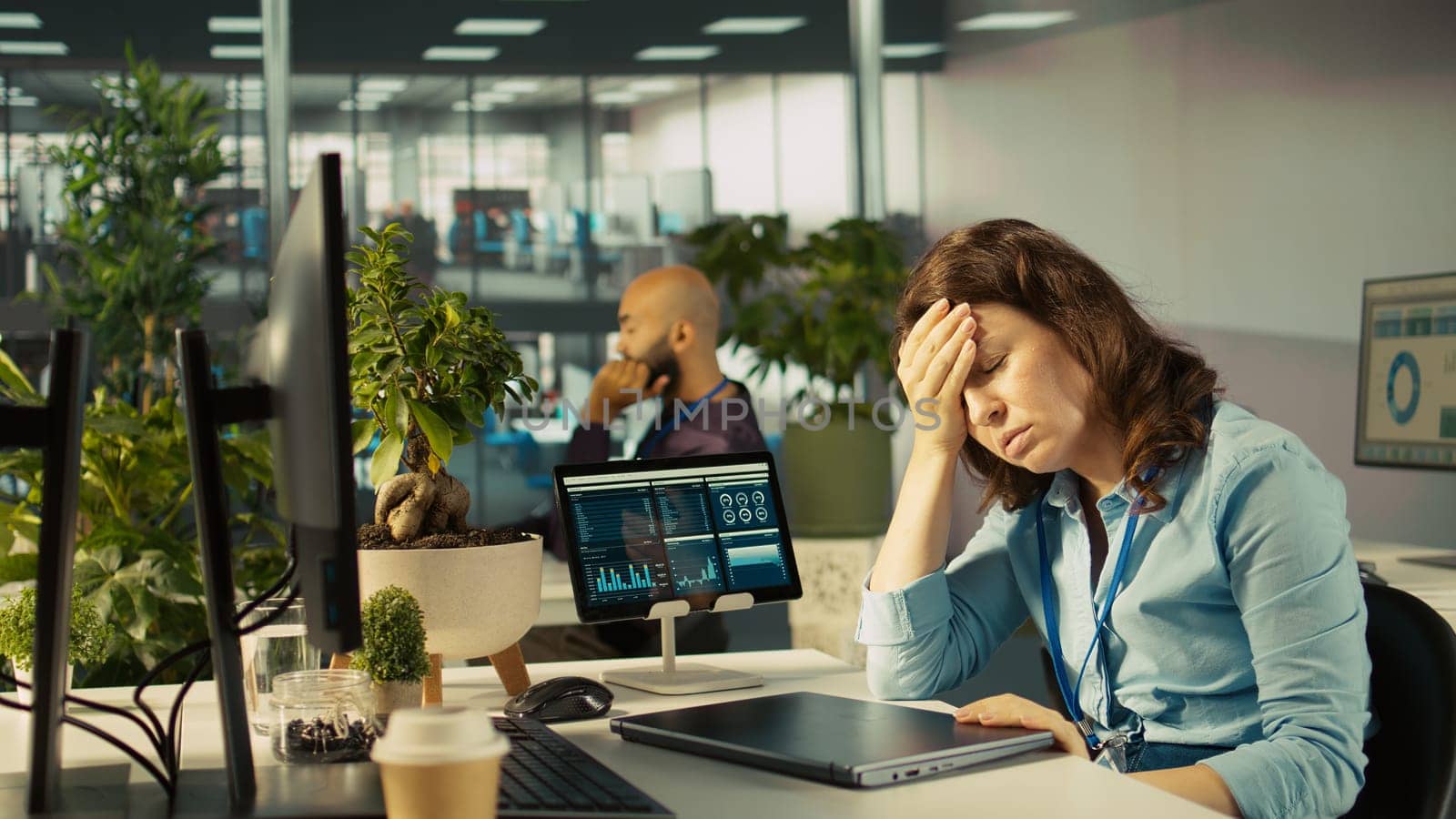 Accountant in busy modern startup agency imputing financial figures on PC after checking reports. Focused businesswoman working in modern office, crosschecking data, camera B
