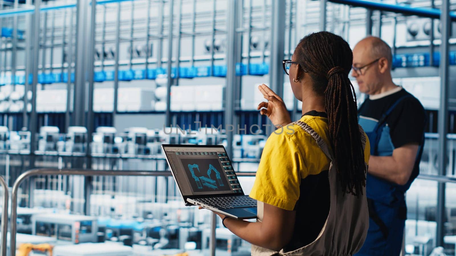 Engineering team working in smart factory, collecting and analyzing data. Teamworking colleagues using tracking software in industry 4.0 industrial plant equipped with advanced sensors, camera A
