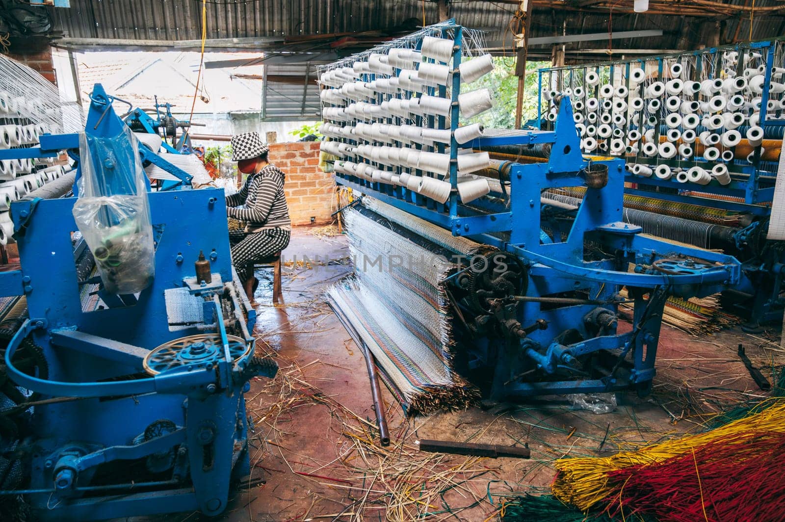 Vietnamese workshop with looms for production of traditional woven reed mats in Vietnam in Asia