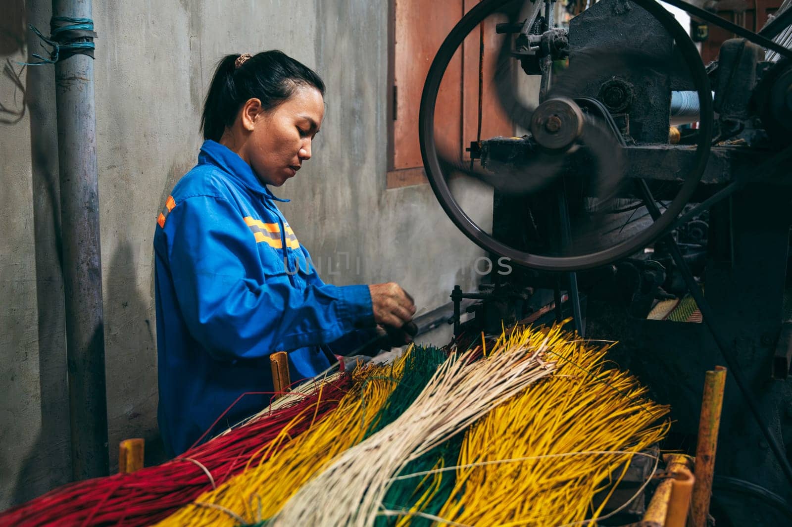 Vietnamese woman works at a loom in factory for the production of woven reed mats. An Cu, Tuy An, Phu Yen province, Vietnam - April 14, 2025