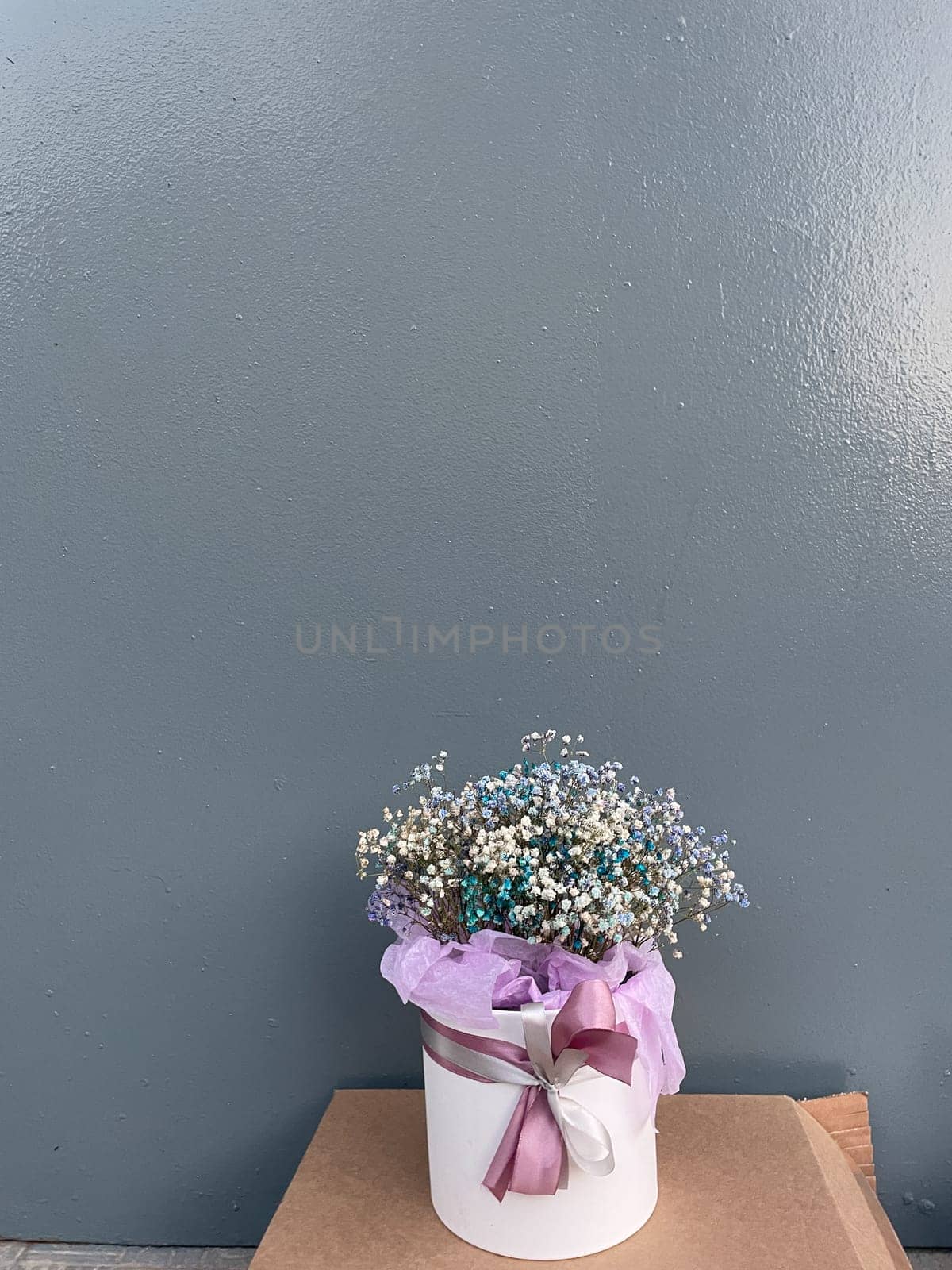 Vase with bouquet of flowers for a gift on a gray background