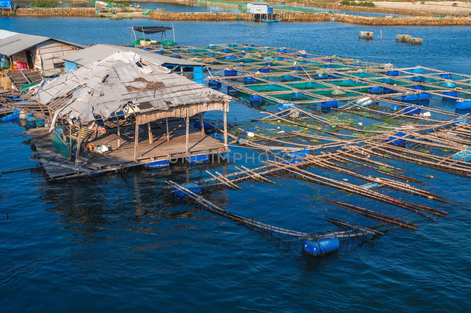 fish farming farm with fishing cages and nets on water in the sea bay in Vietnam in Asia