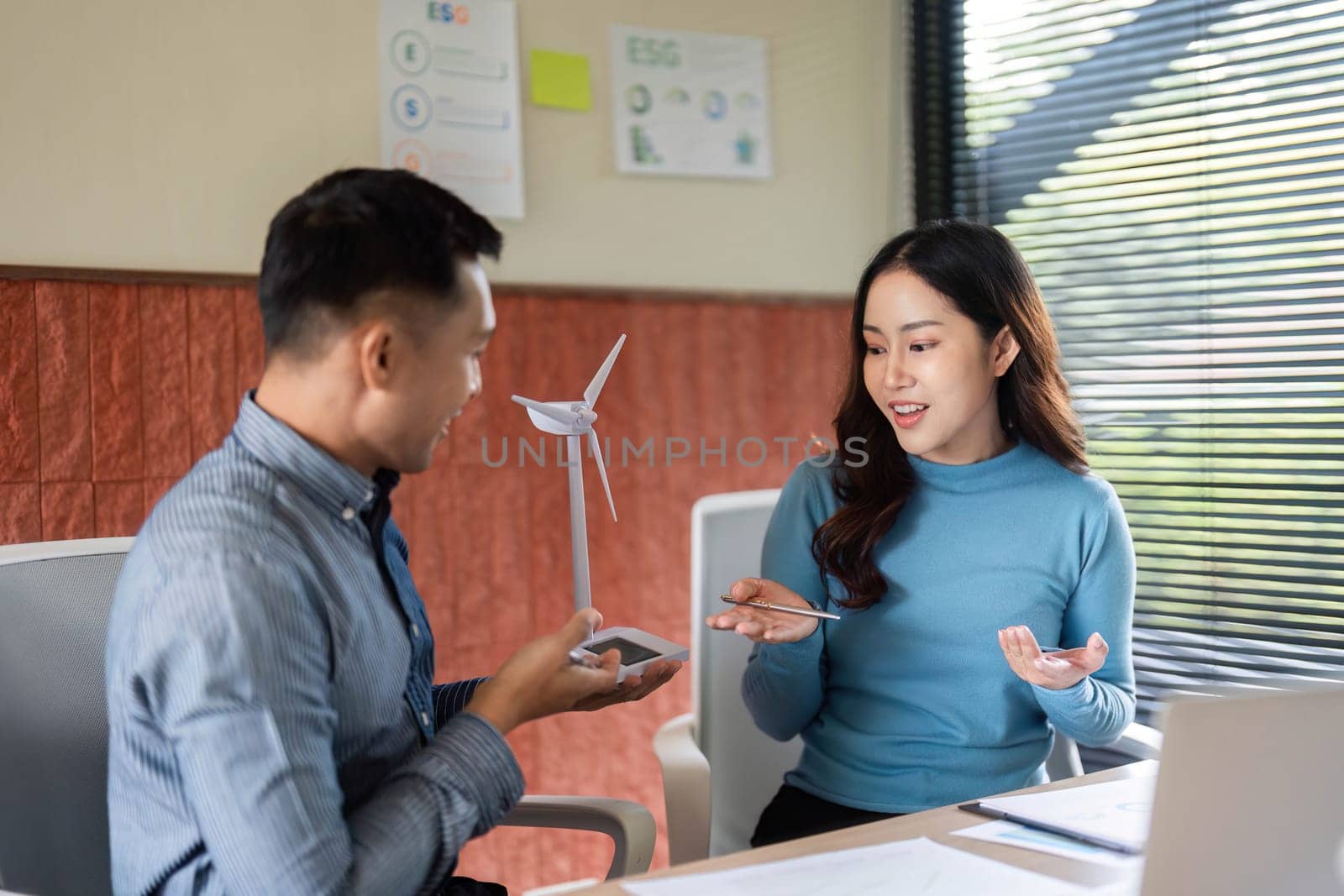 A man and woman engaged in a conversation about ESG initiatives, showcasing teamwork and innovative thinking.