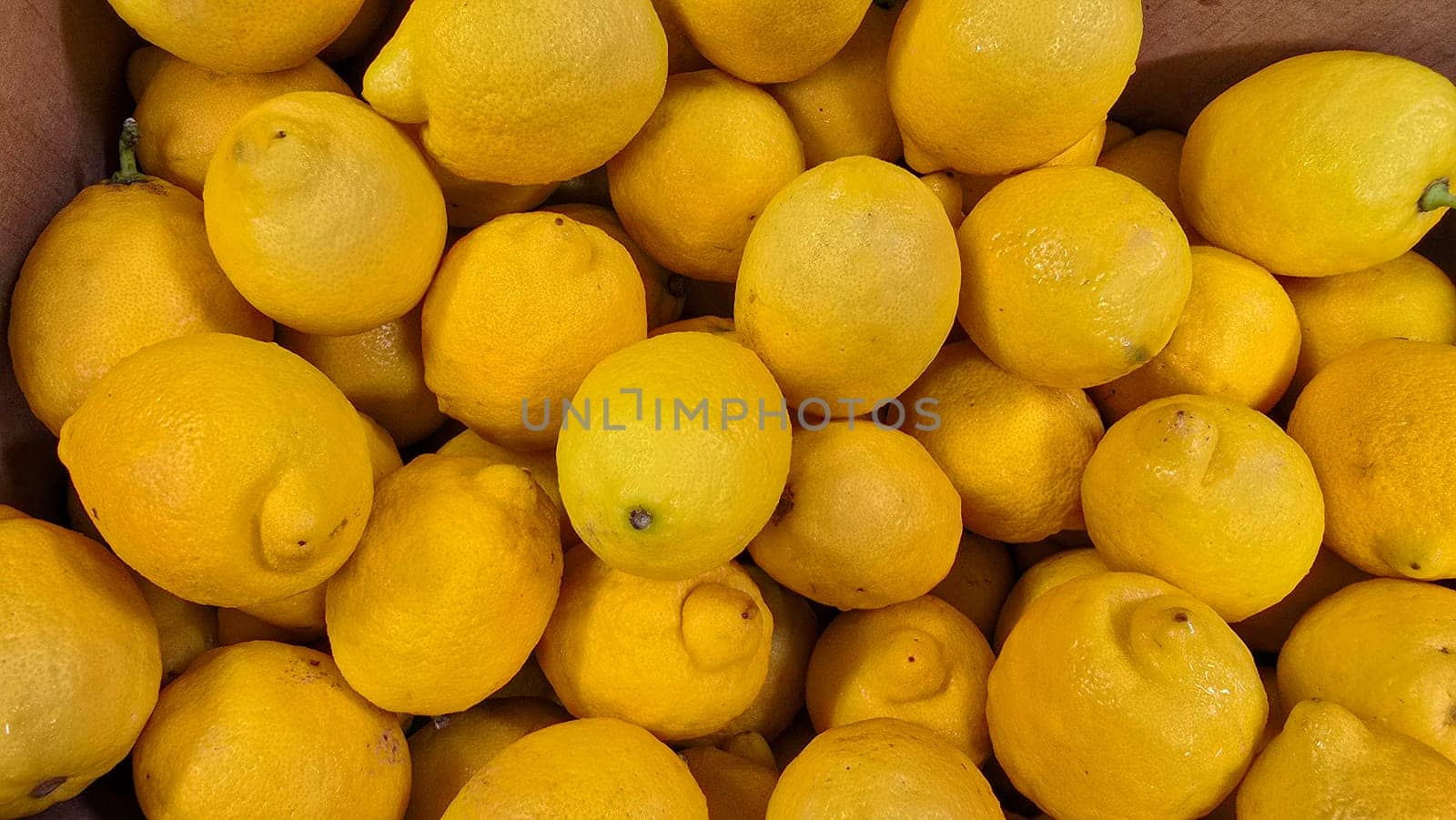 Bright yellow lemons grouped together, presenting an inviting and fresh appearance suitable for culinary or beverage uses, evoking sunny and refreshing vibes. Lemon stack. A vibrant image of fresh, ripe lemons top view. Rich vitamin c, natural and fresh lemon stack