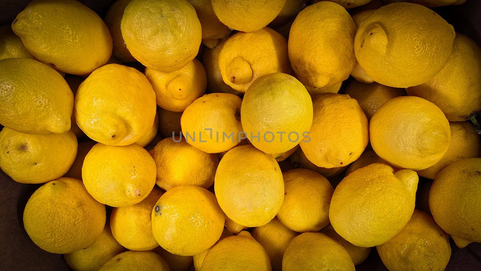 Bright yellow lemons grouped together, presenting an inviting and fresh appearance suitable for culinary or beverage uses, evoking sunny and refreshing vibes. Lemon stack. A vibrant image of fresh, ripe lemons top view. Rich vitamin c, natural and fresh lemon stack