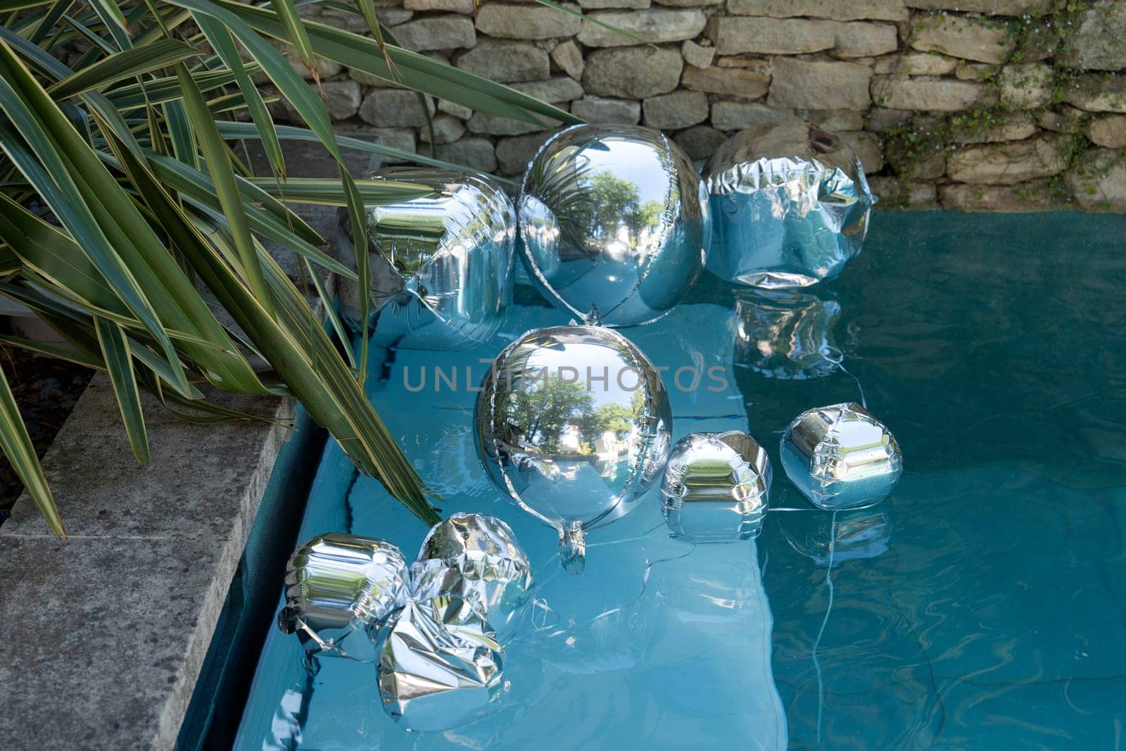 Silver balloons float in pools for a birthday party decorations
