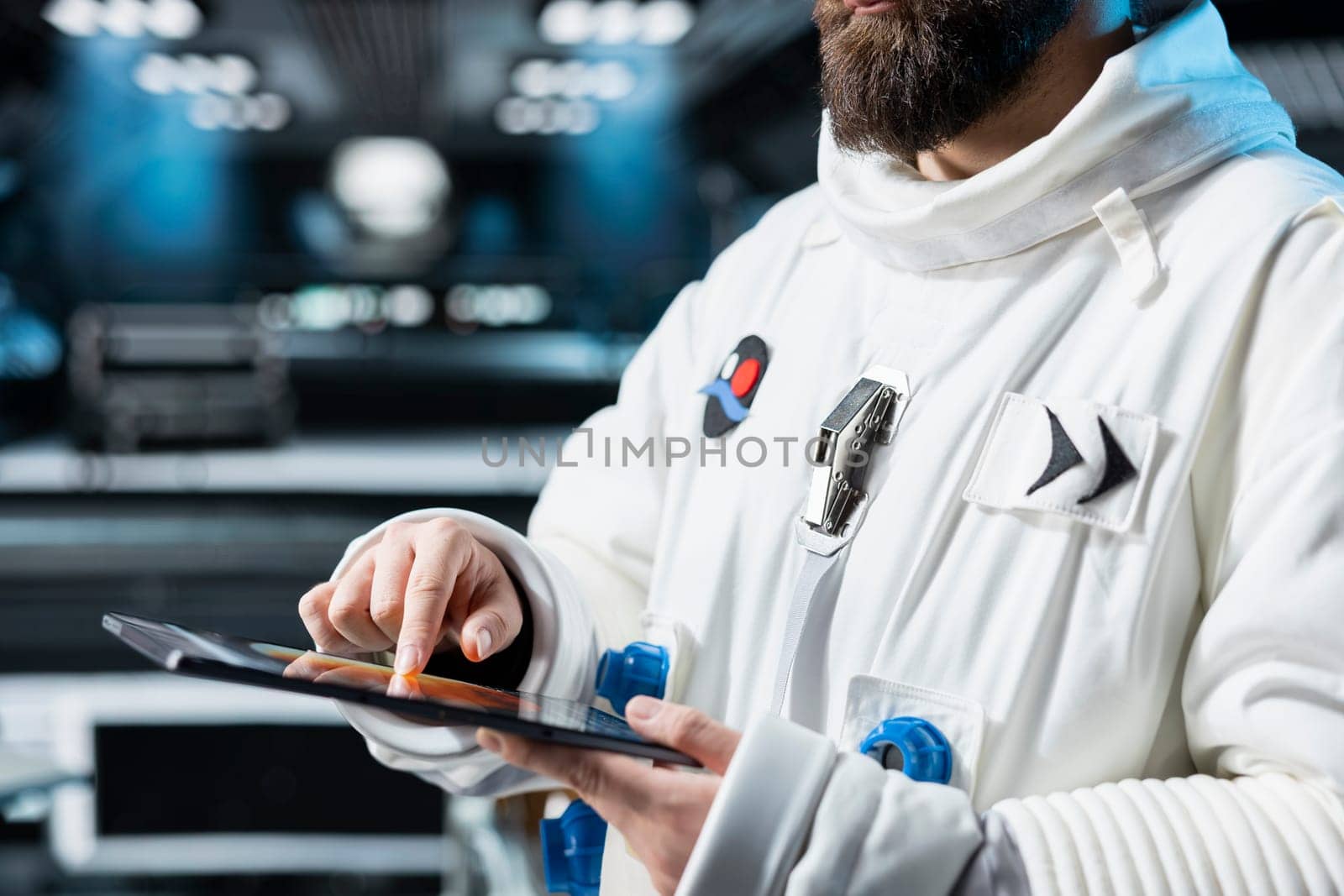 Close up of astronaut running telemetry software on tablet to confirm suit integrity. Orbital station crew member testing gear during routine equipment check, reviewing onboard analytics