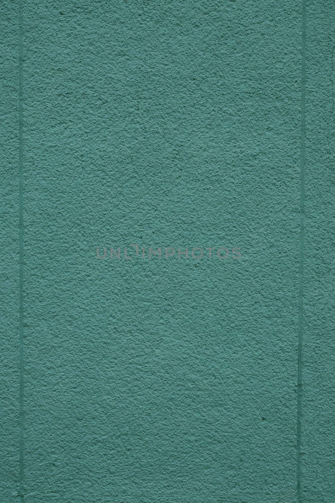 Concrete wall painted green, close-up. Plaster texture. House facade.