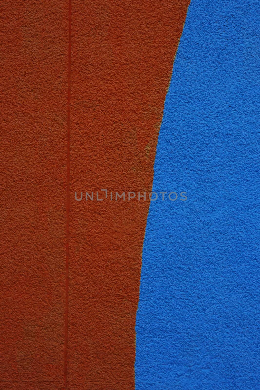 Freshly painted wall, half blue and half brown.