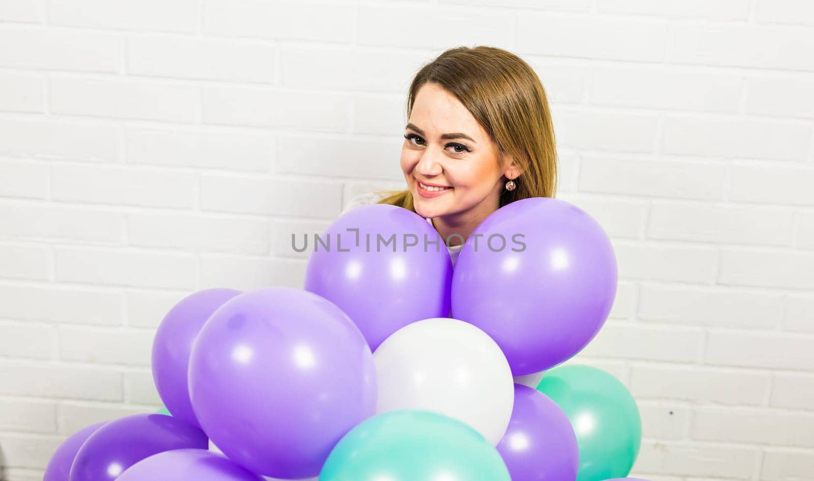 Young pretty woman with colored balloons indoors