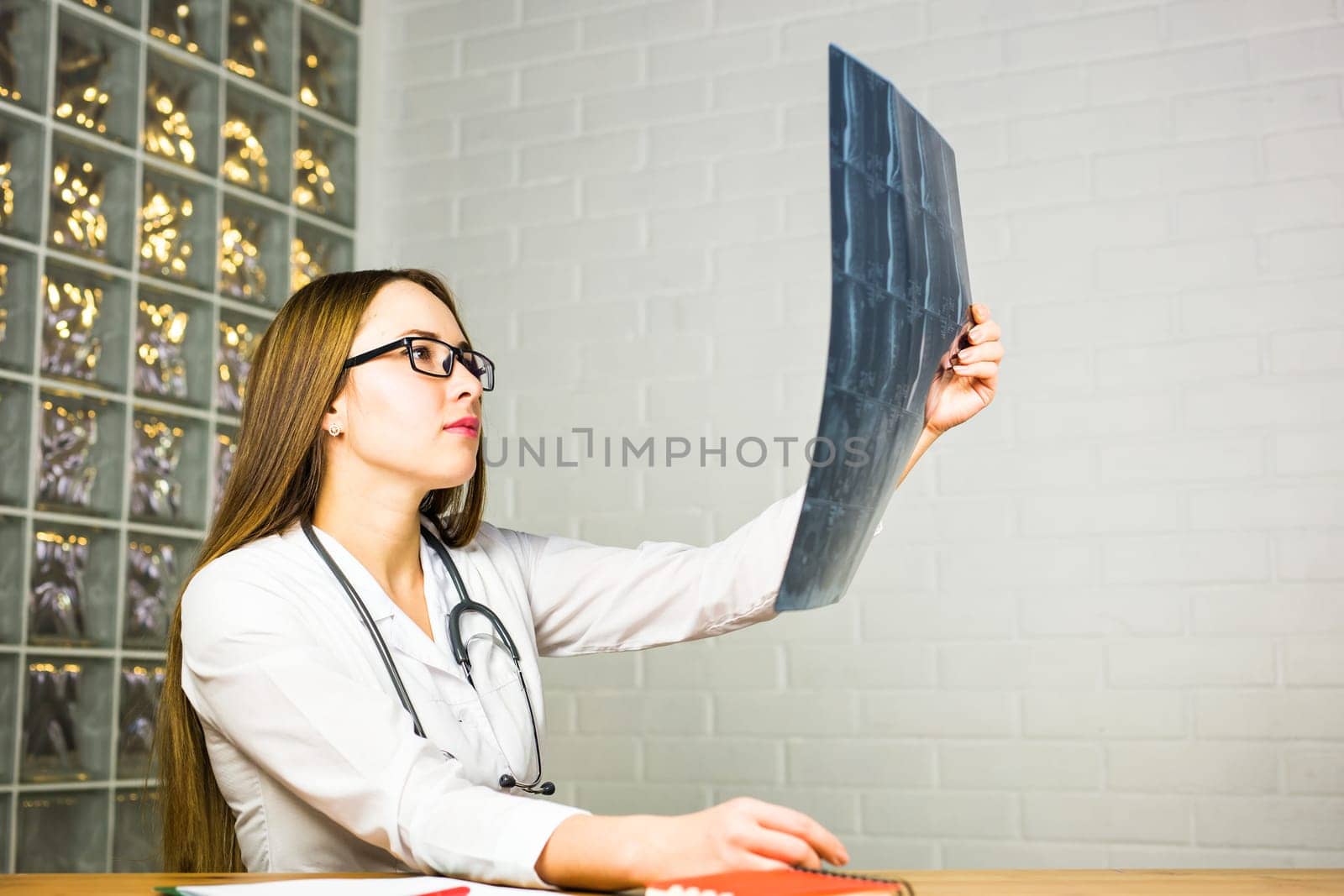 Young female doctor looking at the x-ray picture in hospital.