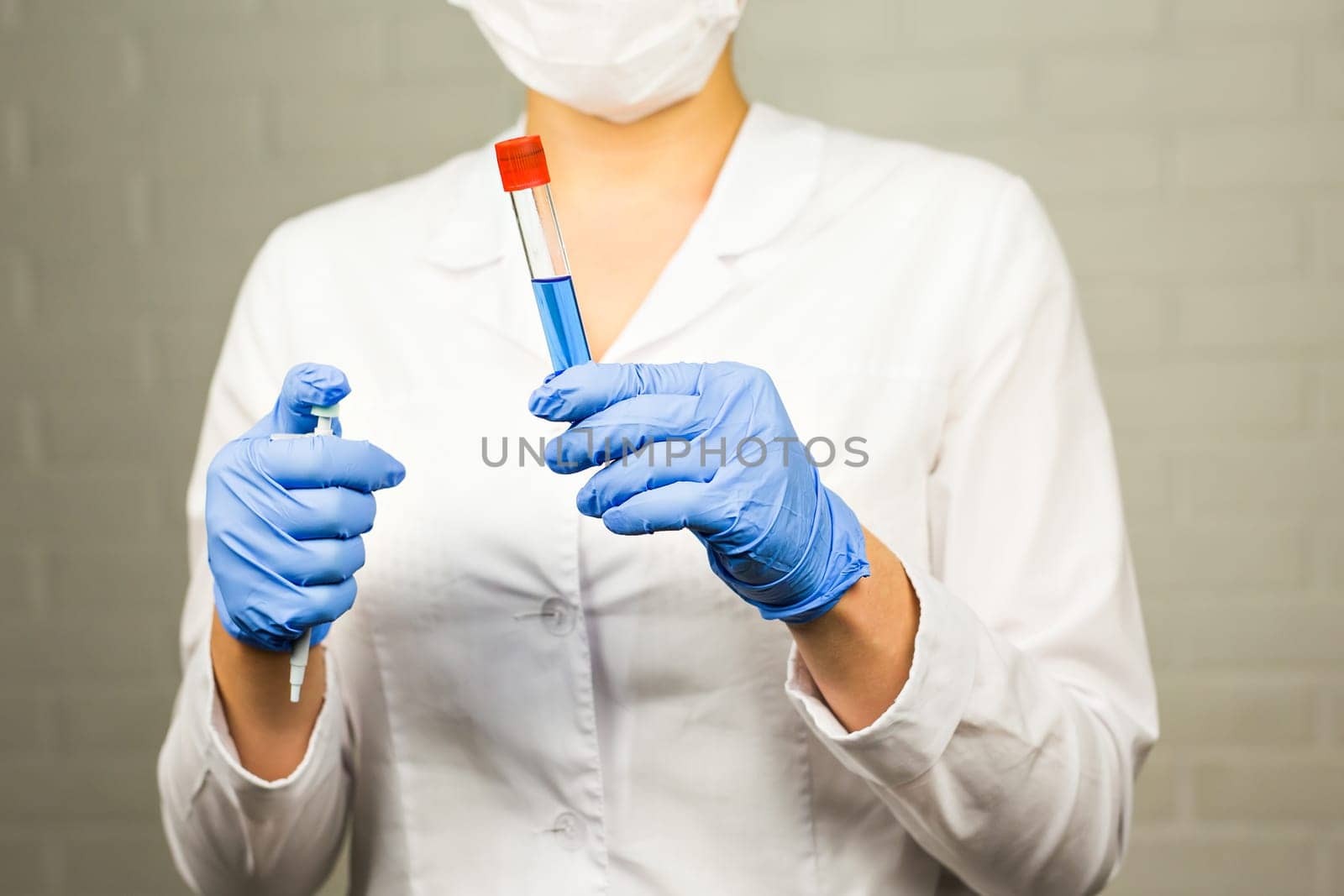 science, chemistry, biology, medicine and people concept - close up of young female scientist holding tube with sample making and test or research in clinical laboratory