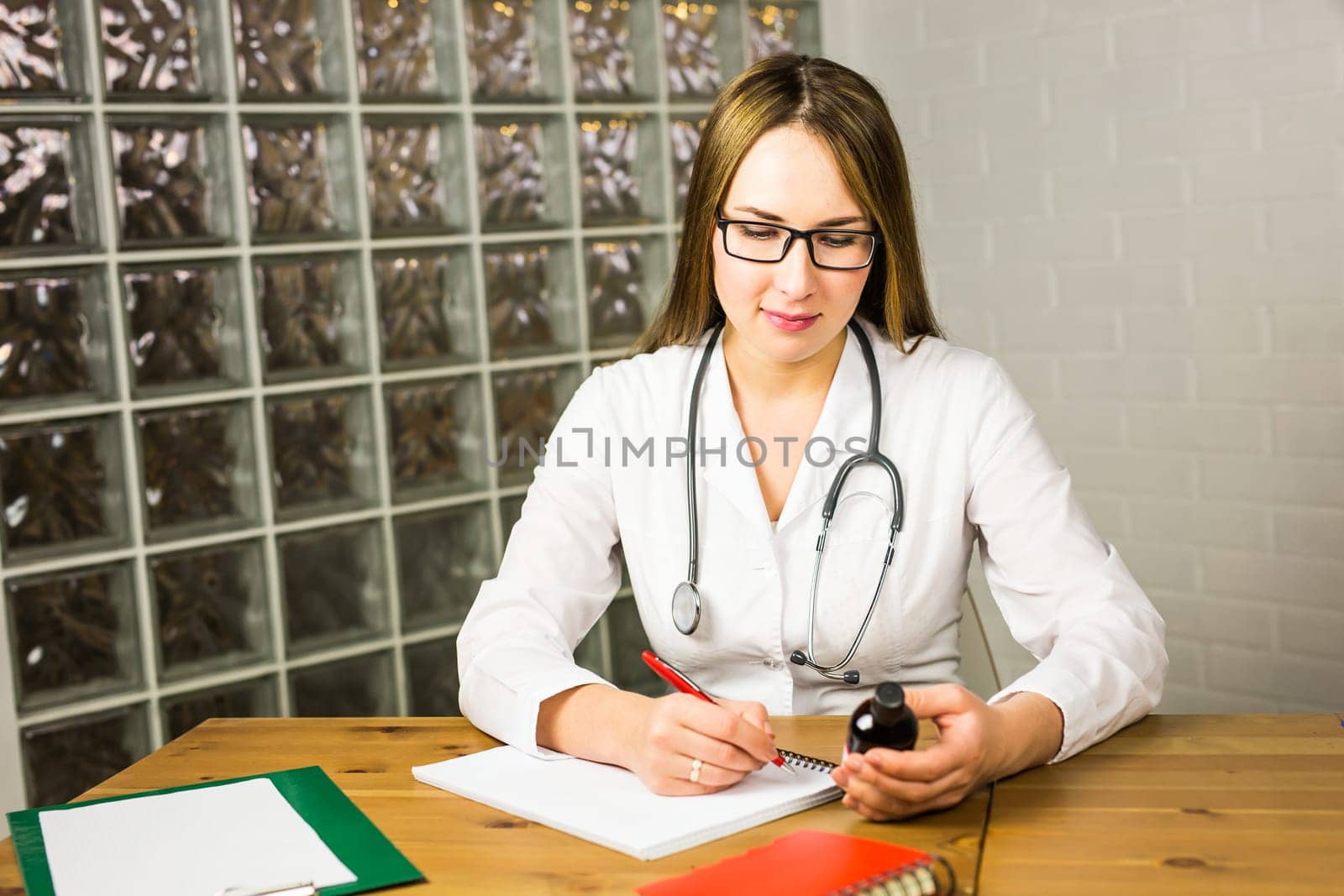 female doctor writing a prescription. young doctor writes a prescription drug in Notepad