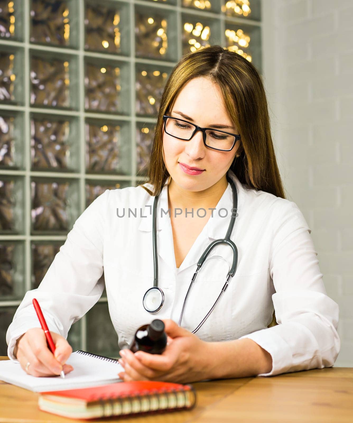 female doctor writing a prescription. young doctor writes a prescription drug in Notepad