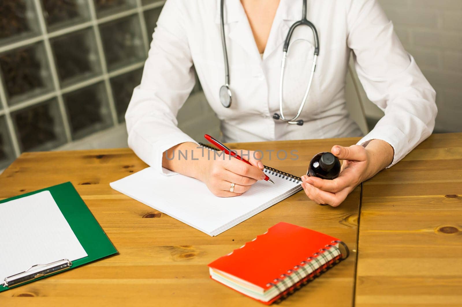 female doctor writing a prescription. young doctor writes a prescription drug in Notepad