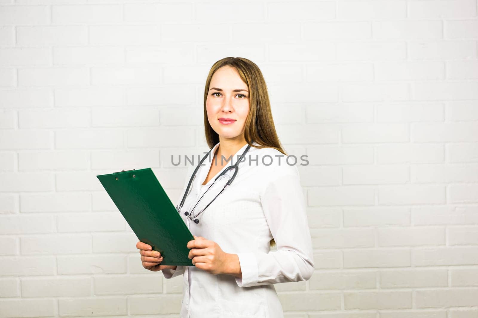 Smiling medical doctor woman with stethoscope on white background.