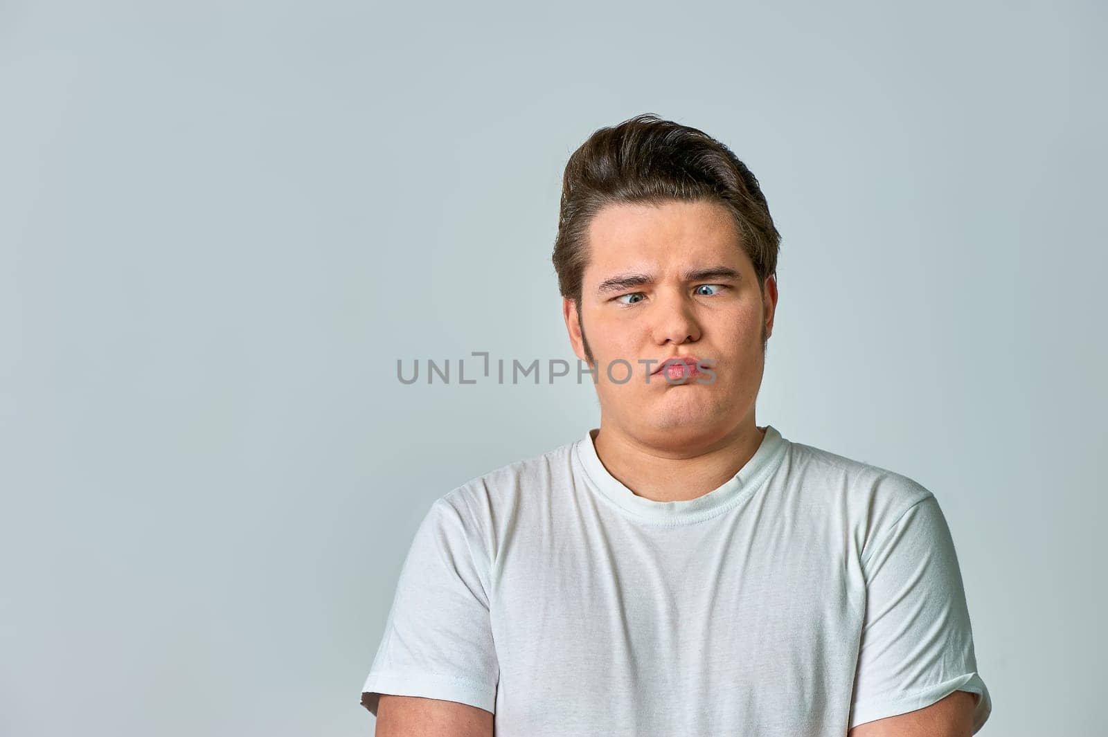 the man on the gray background brought his eyes together. High quality photo