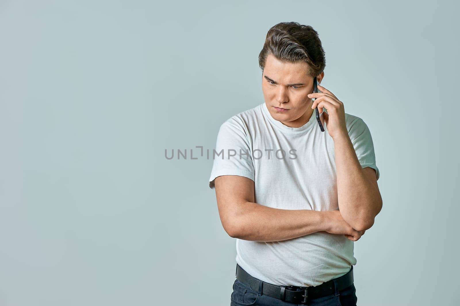 a man on a gray background is talking on the phone. High quality photo