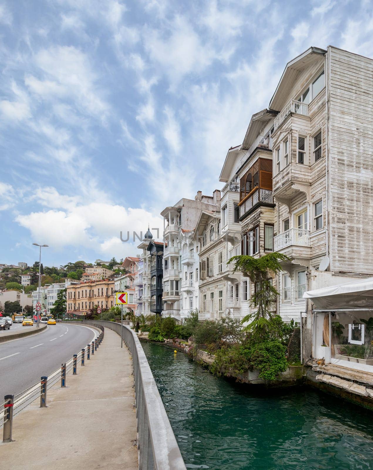 Wooden traditional residential buildings by a narrow water canal near Bosphorus strait, in Arnavutkoy neighborhood, Besiktas district, Istanbul, Turkiye, in a sunny spring day
