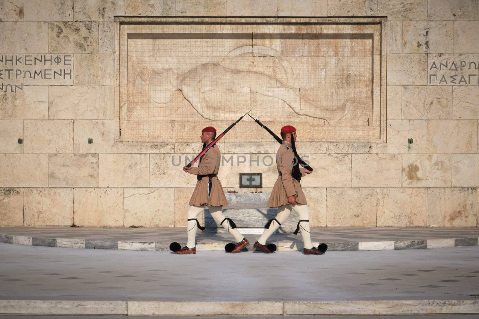 Ceremony of Presidential guard Evzones by the Greek tomb of Unknown Soldier. Evzones in summer uniform walk away from each other. Close shot.