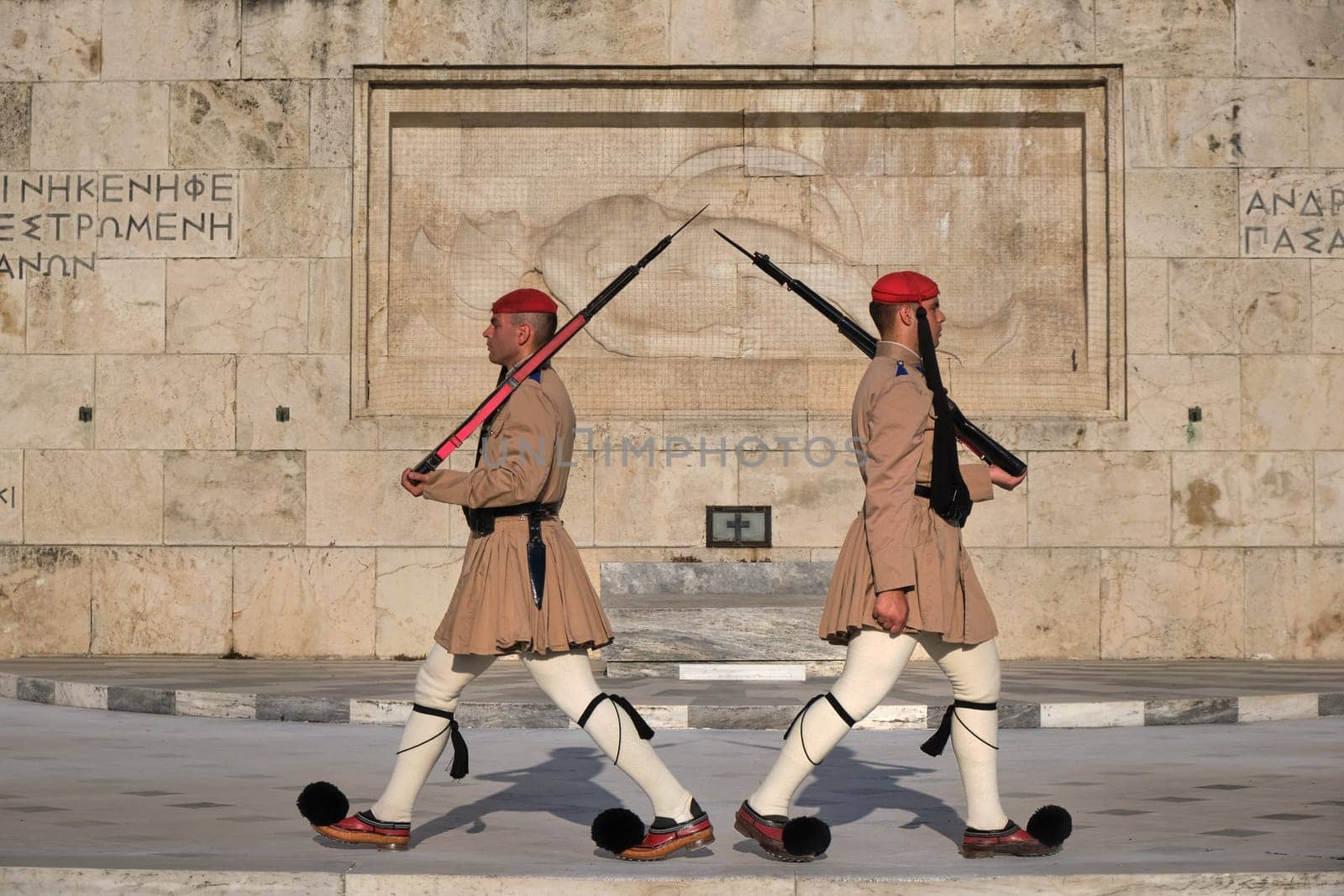 Ceremony of Presidential guard Evzones by the Greek tomb of Unknown Soldier. Evzones in summer uniform stand as one, still. Close-up shot.