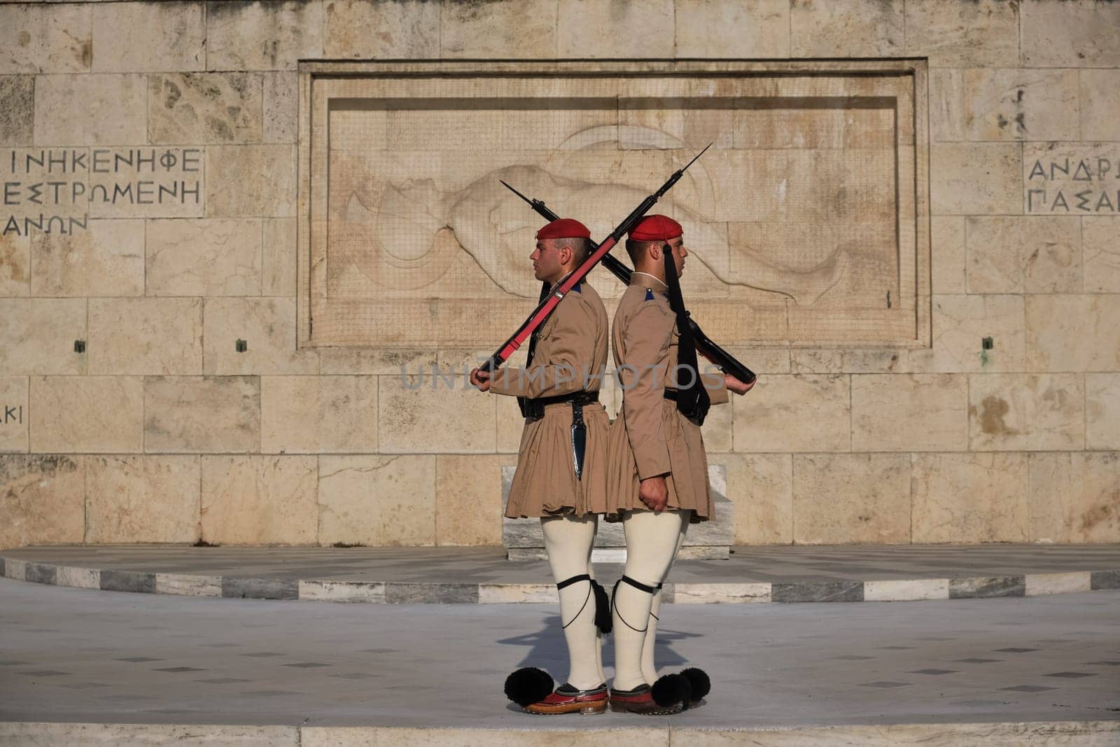 Ceremony of Presidential guard Evzones by the Greek tomb of Unknown Soldier. Evzones in summer uniform stand as one, still. Close-up shot.