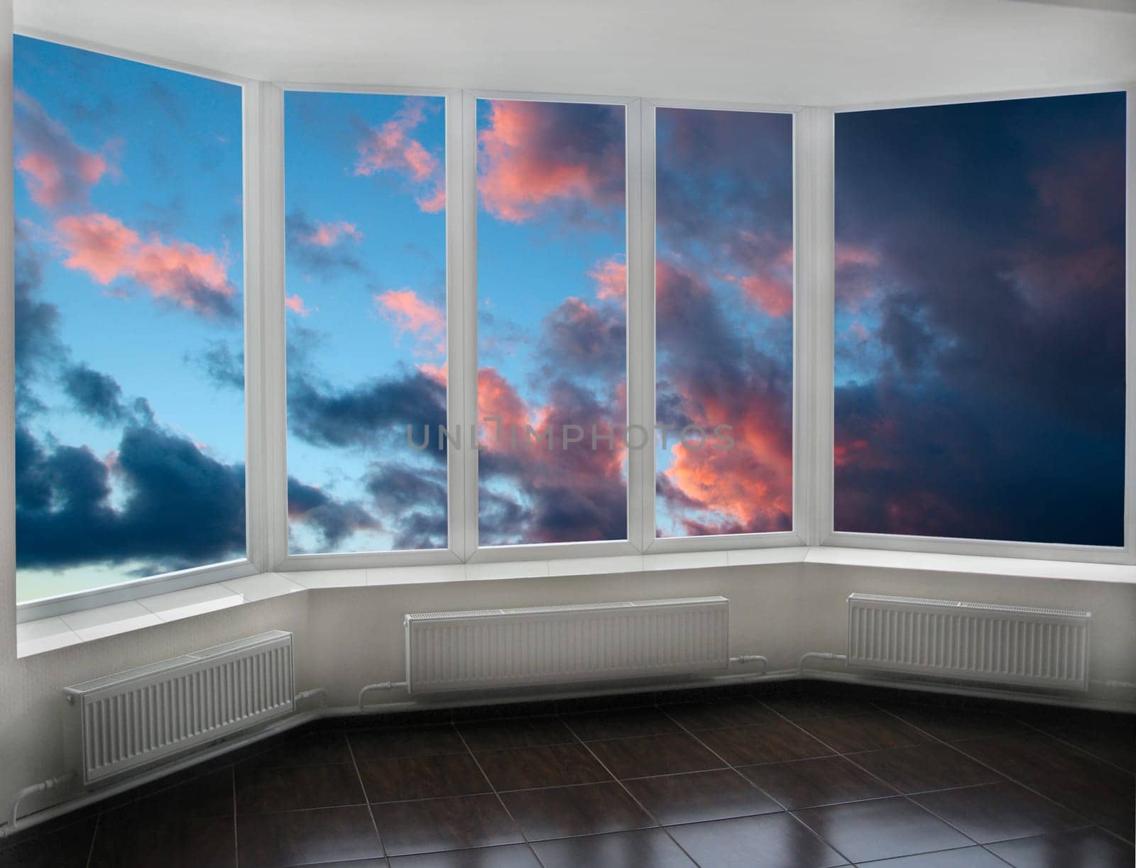 Plastic windows overlooking beautiful dark sunset. View from home window at sunset. Golden sunset outside window. Evening outside window. Modern window on veranda with panorama