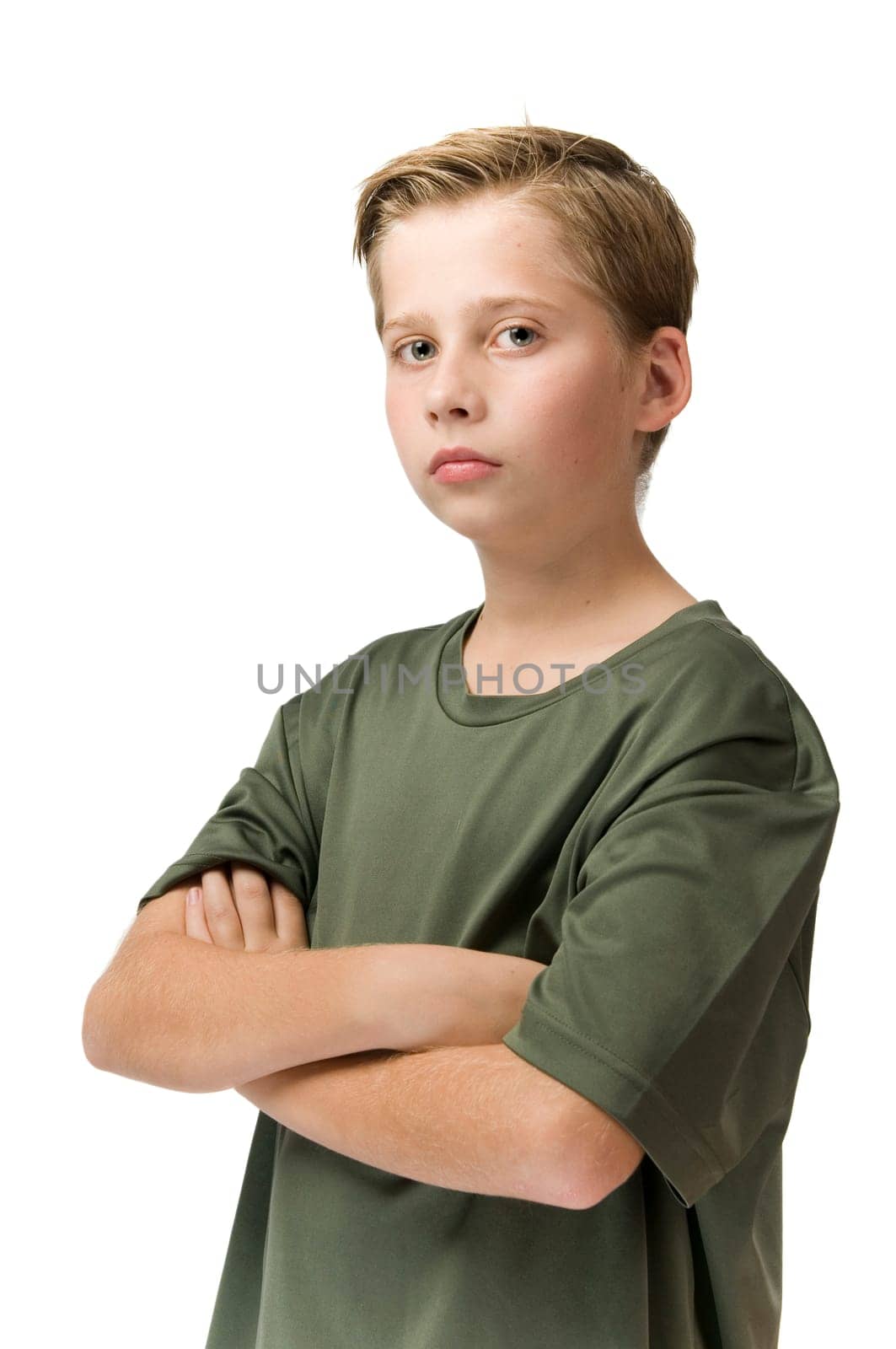 Three quarter waist view of a young teenager in a t-shirt and arms crossed looking pouty at the camera.