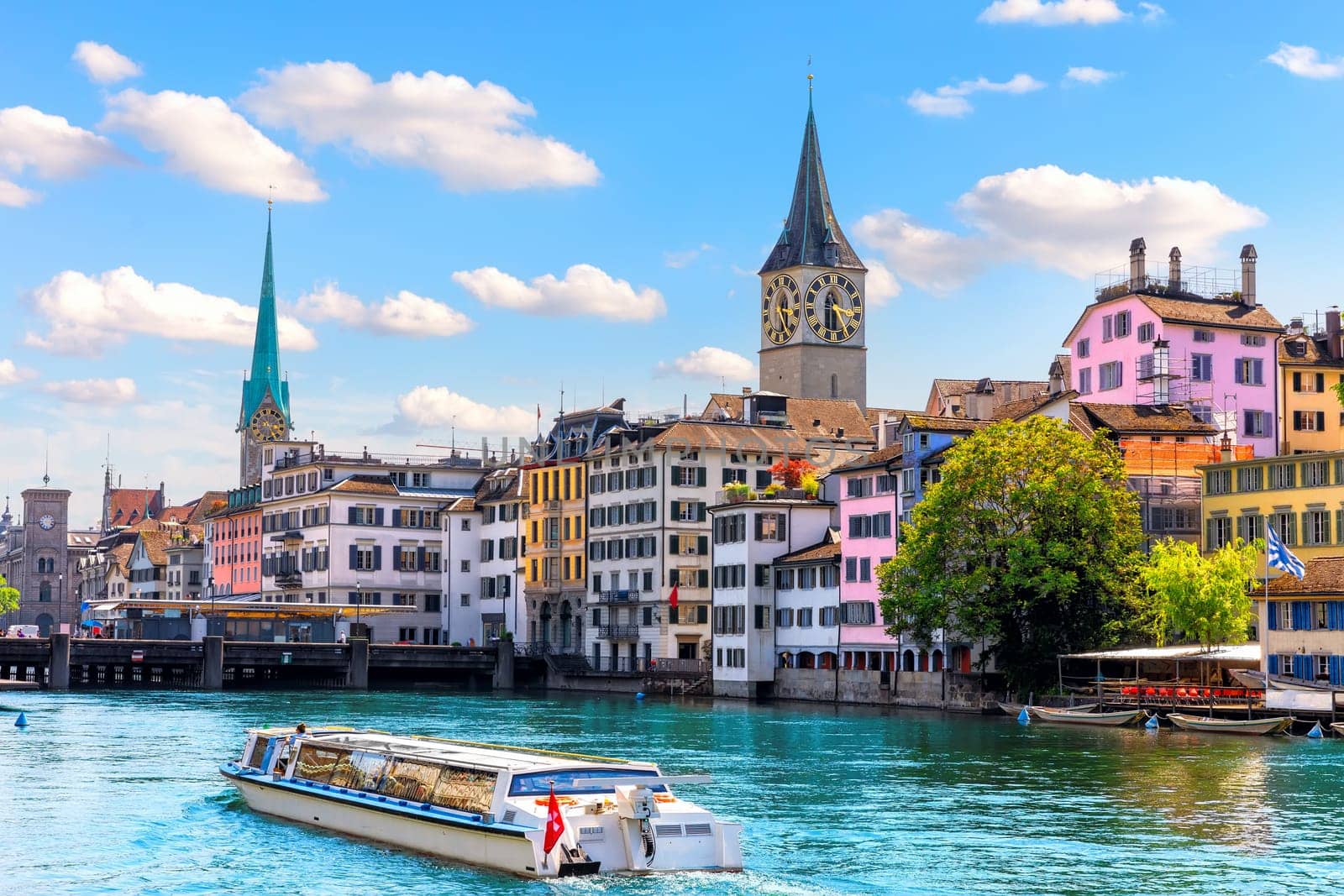 Ship is sailing by St. Peter's church and Fraum nster abbey, the two most popular places of visit in Zurich, Switzerland.