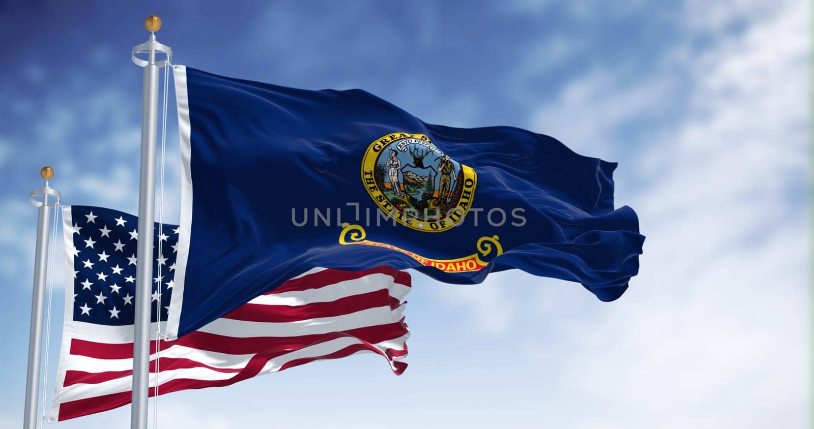 The Idaho state flag waving along with the national flag of the United States of America on a clear day. 3D illustration render. Rippled fabric
