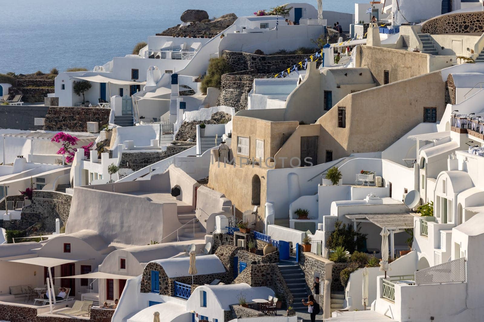 Oia, Santorini, Greece - June 28, 2021: Whitewashed houses in Oia on Santorini island, Cyclades, Greece