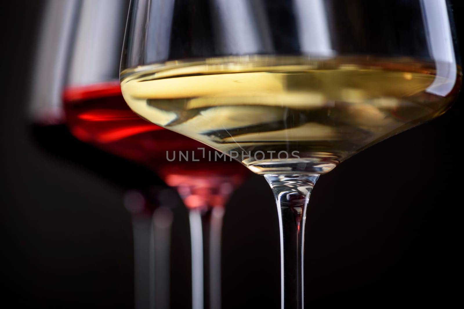 Three glass of red, rose and white wine over black background. Wine card menu design. Closeup of wineglasses with luxury wines for wine tasting.