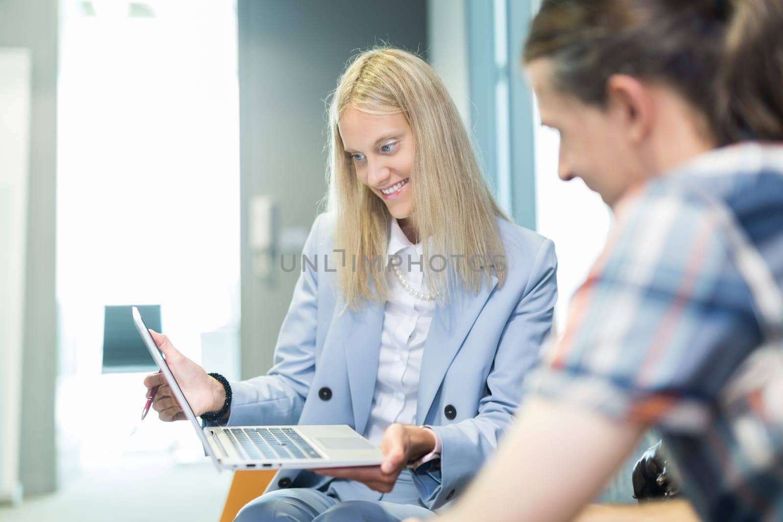 Business meeting. Client consulting. Confident business woman, real estate agent, financial advisor explaining details of project or financial product to client in office