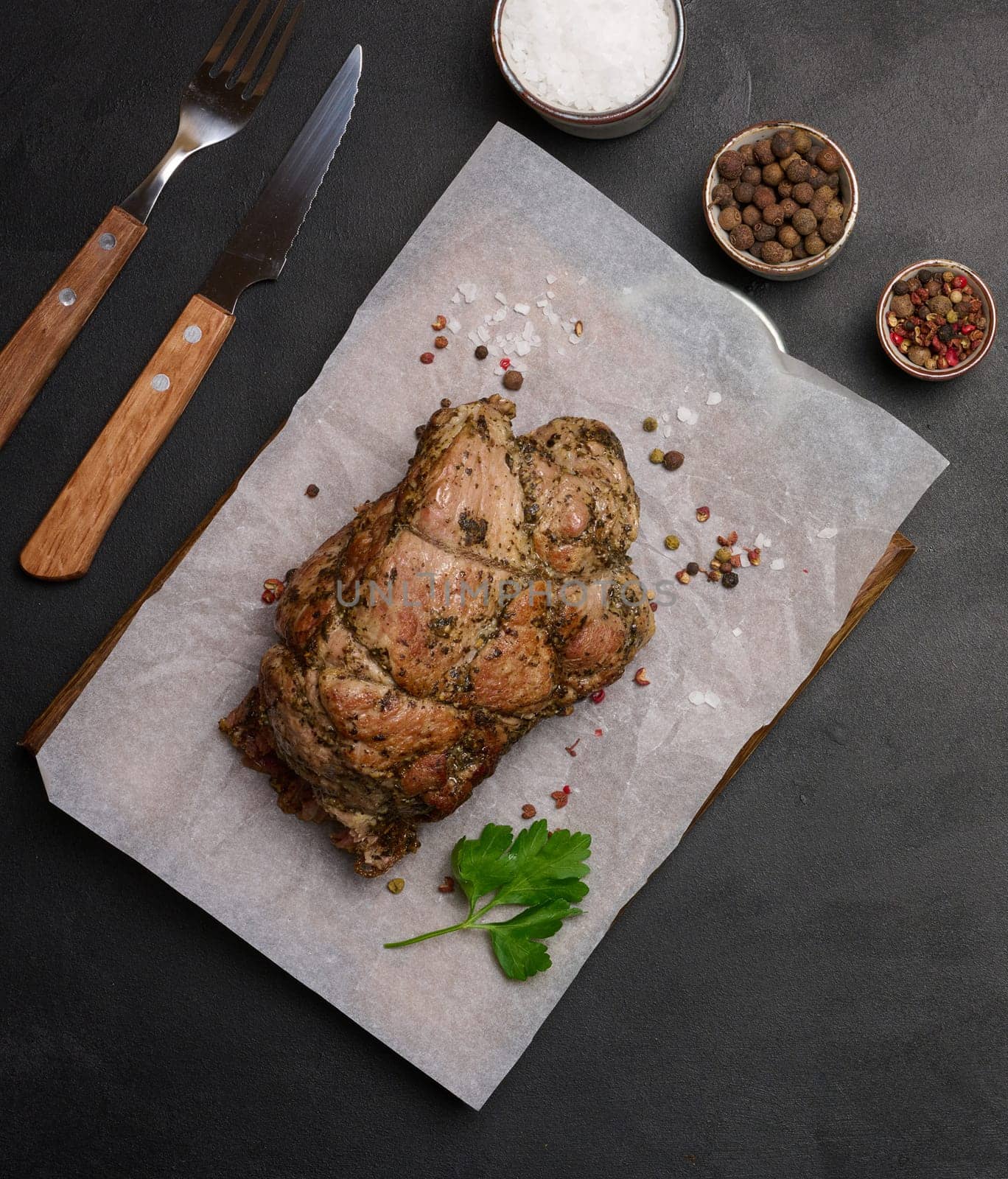 Baked pork collar with spices on a wooden board, delicious and juicy meat