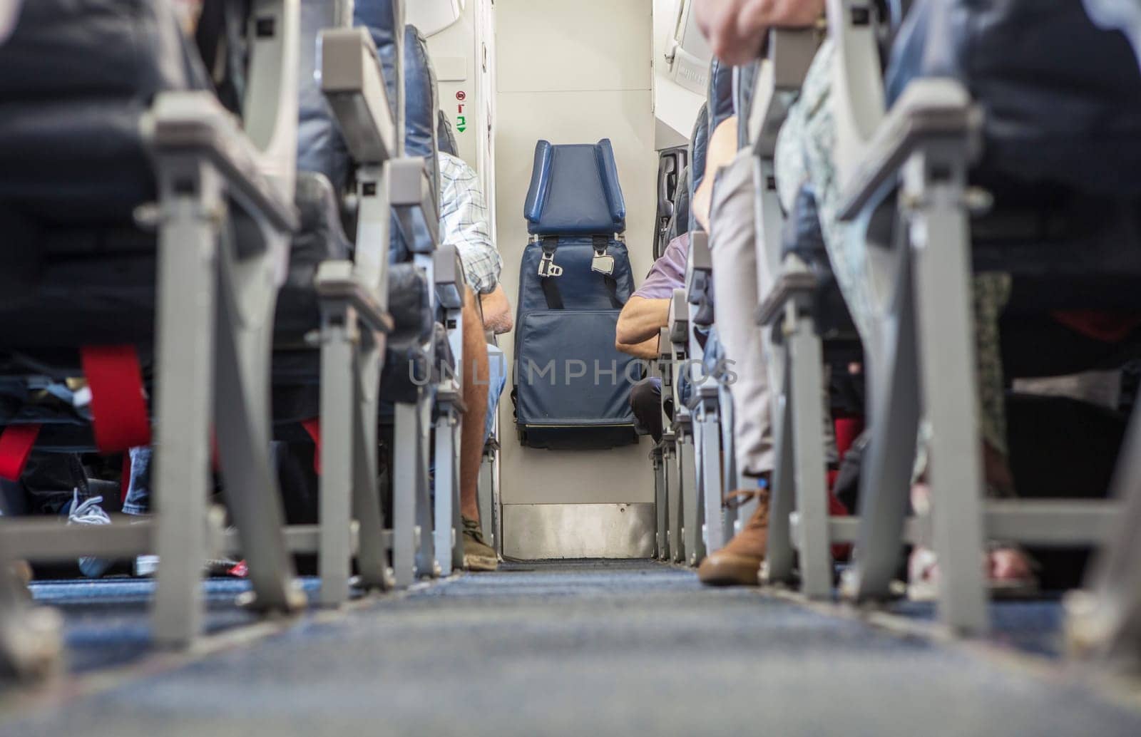 Normal class passenger jet airliner corridor. Tail stewardess seat