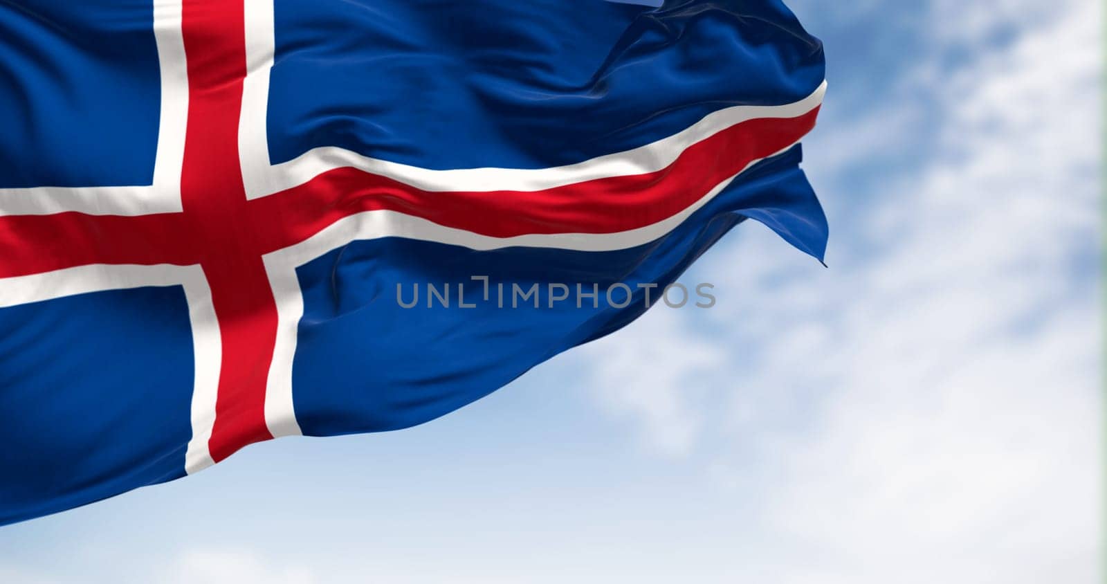 Iceland national flag waving in the wind on a clear day. Blue flag with a white-edged red Nordic cross. 3d illustration render. Fluttering fabric.