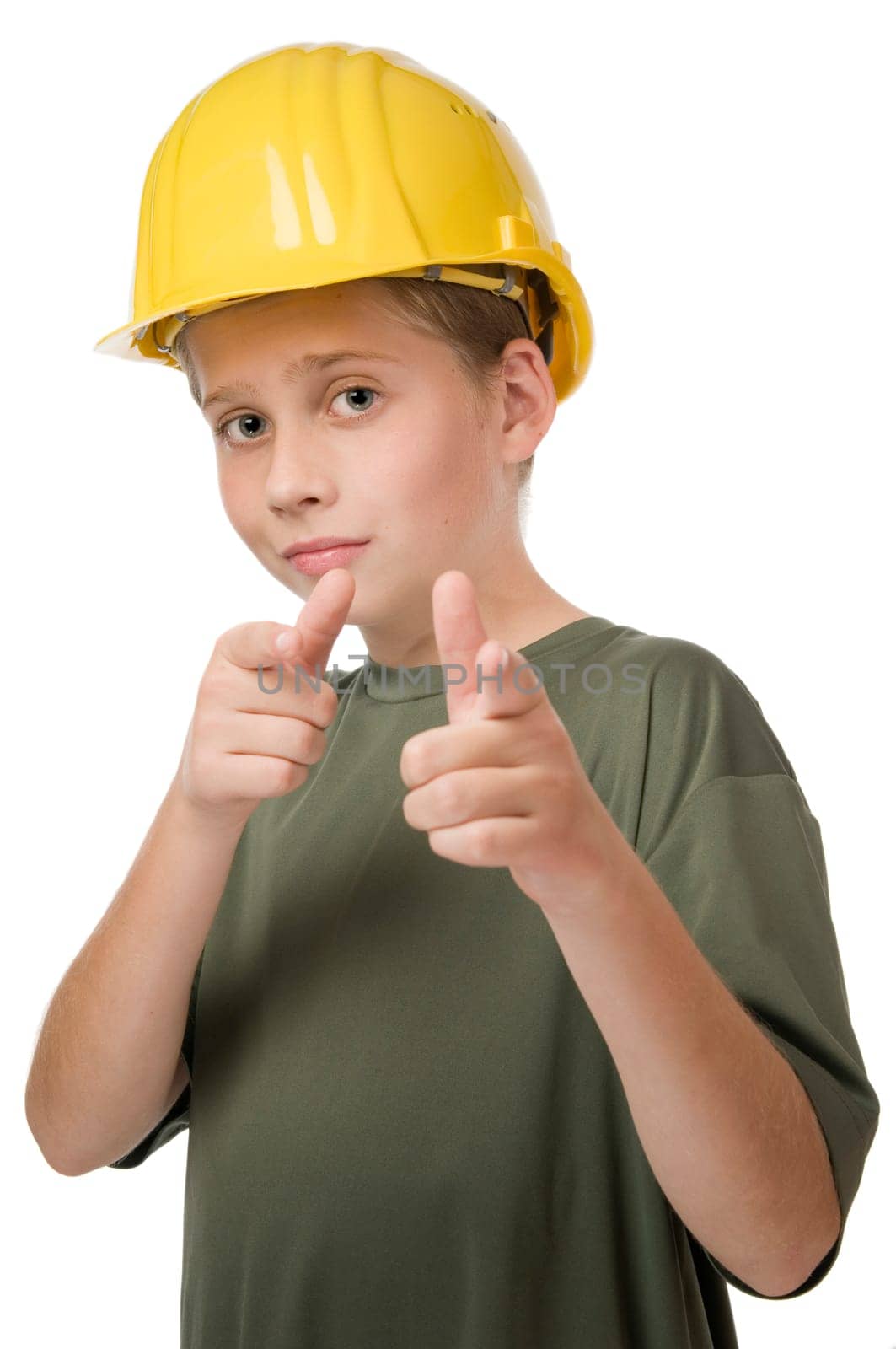 Waist up view of young teenage boy wearing yellow helmet pointing fingers at camera.