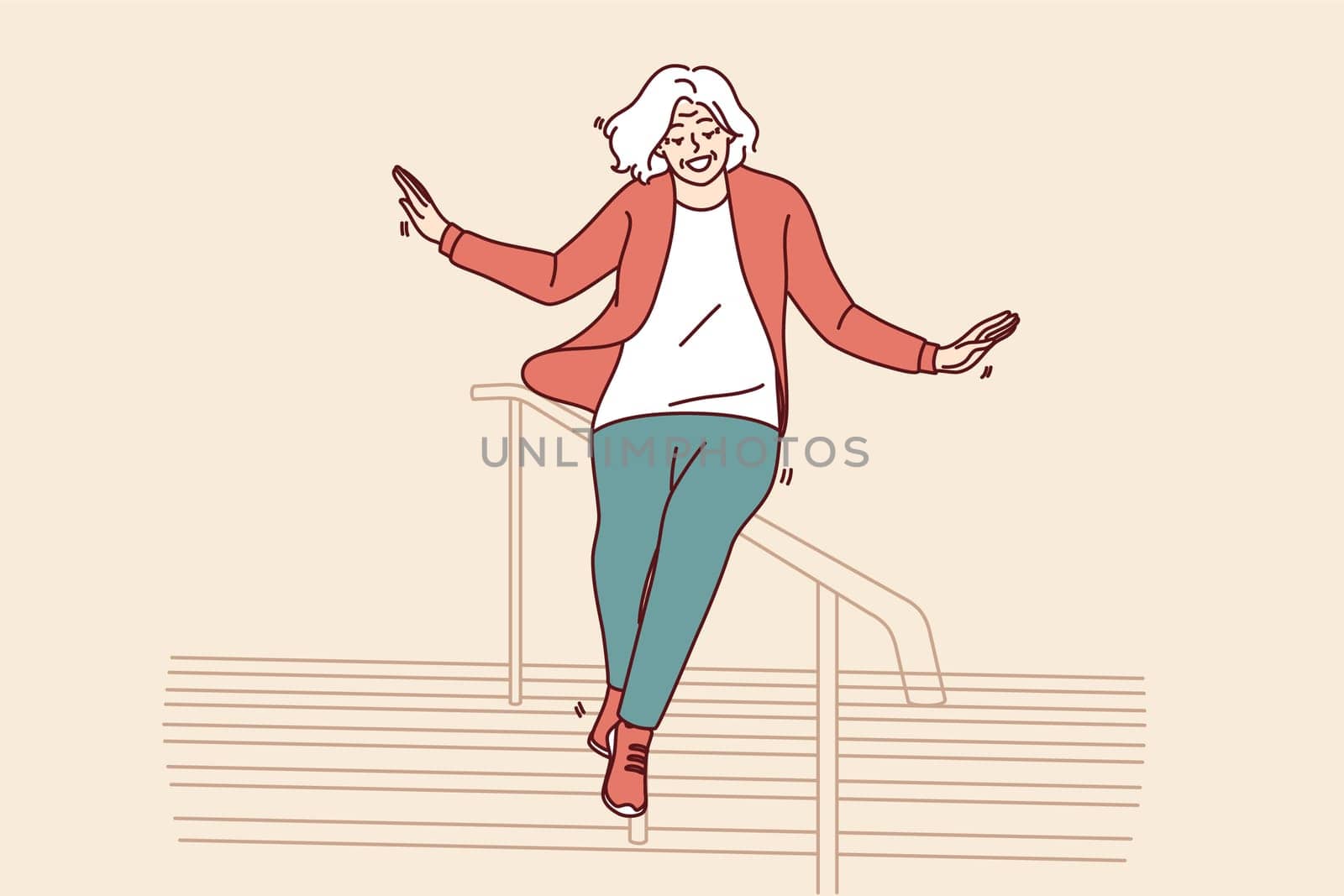 Elderly woman slides down stair railing having fun and being active after retirement. Cheerful elderly woman in casual clothes feels full of energy and laughs regardless of mature age