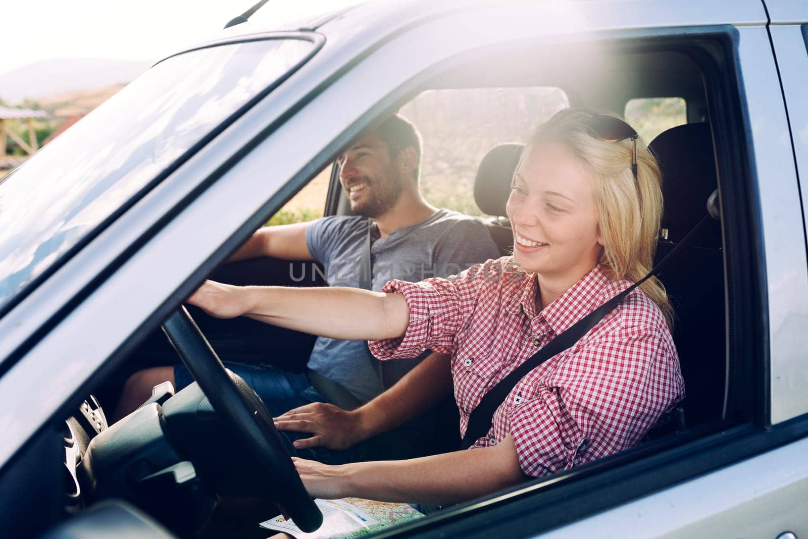 Happy couple traveling by car in nature. Carefree friend travelers on countryside roadtrip journey. Young woman and man driving on romantic weekend.
