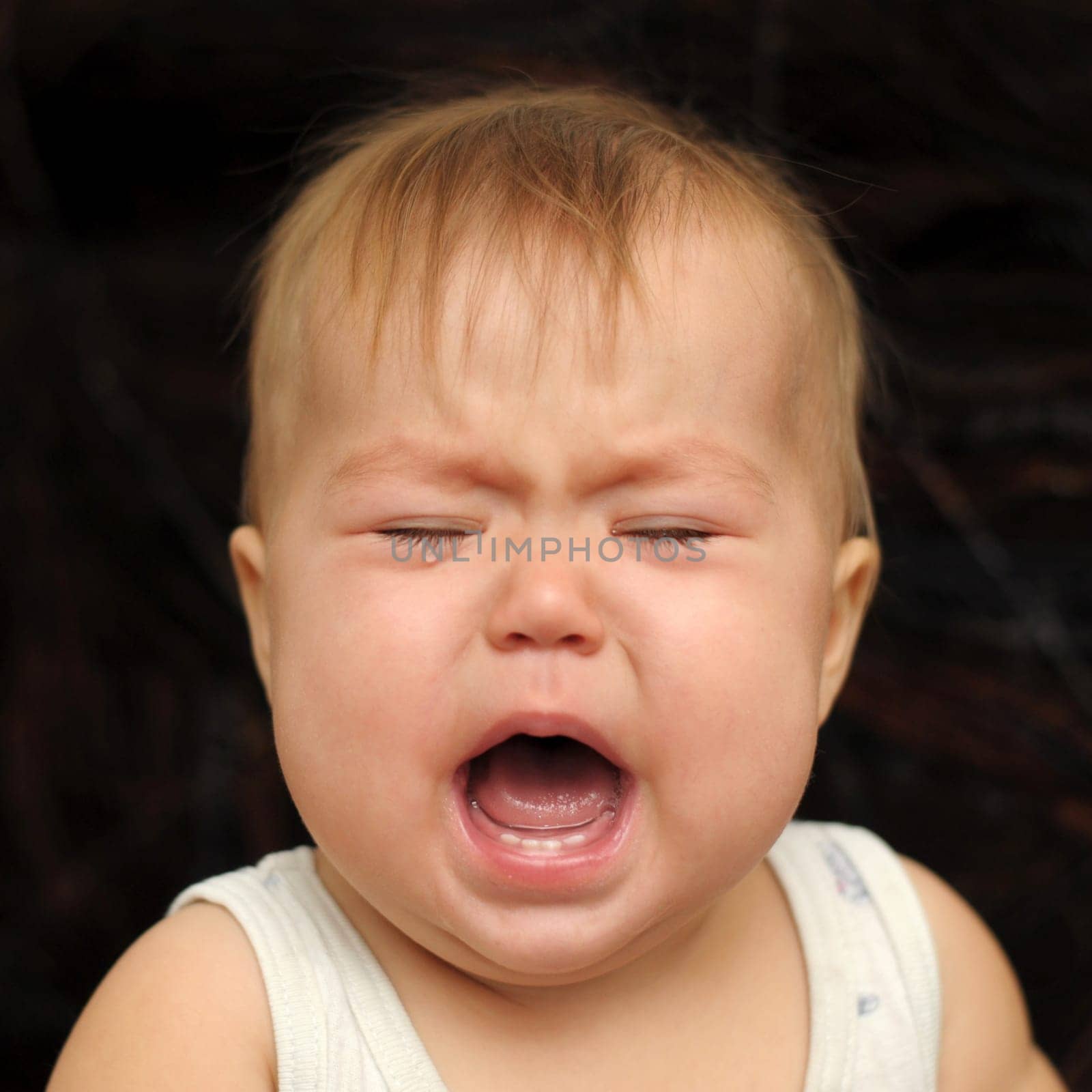 Portrait of nine month baby crying very emotionally