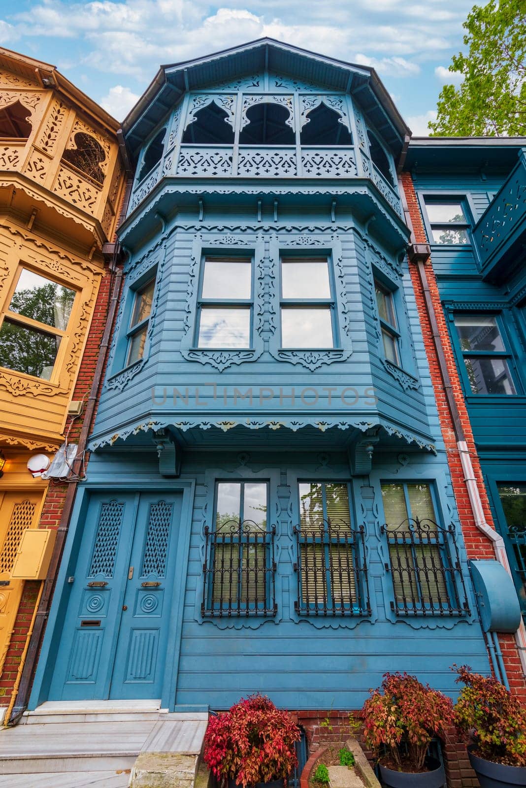 Facade of colorful wooden residential building painted in blue, with wrought iron window, at an alley suited in Kuzguncuk neighborhood, Uskudar district, Istanbul, Turkey