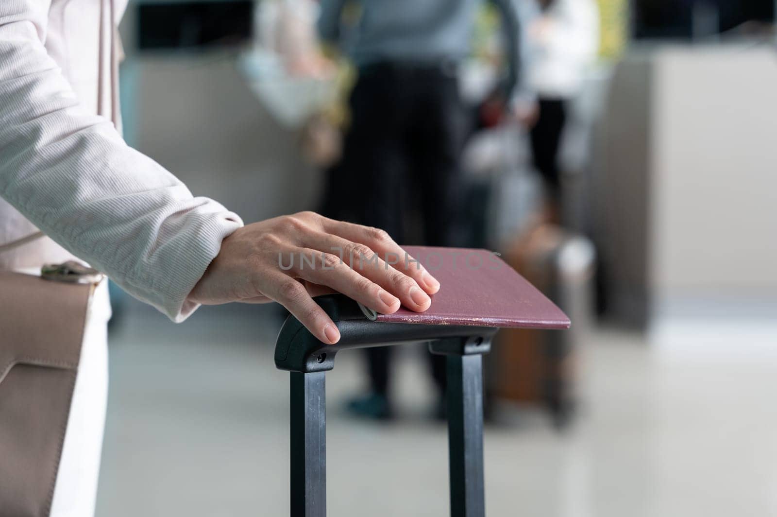 Business woman holding passport with luggage at airport terminal, travel and tourism concept