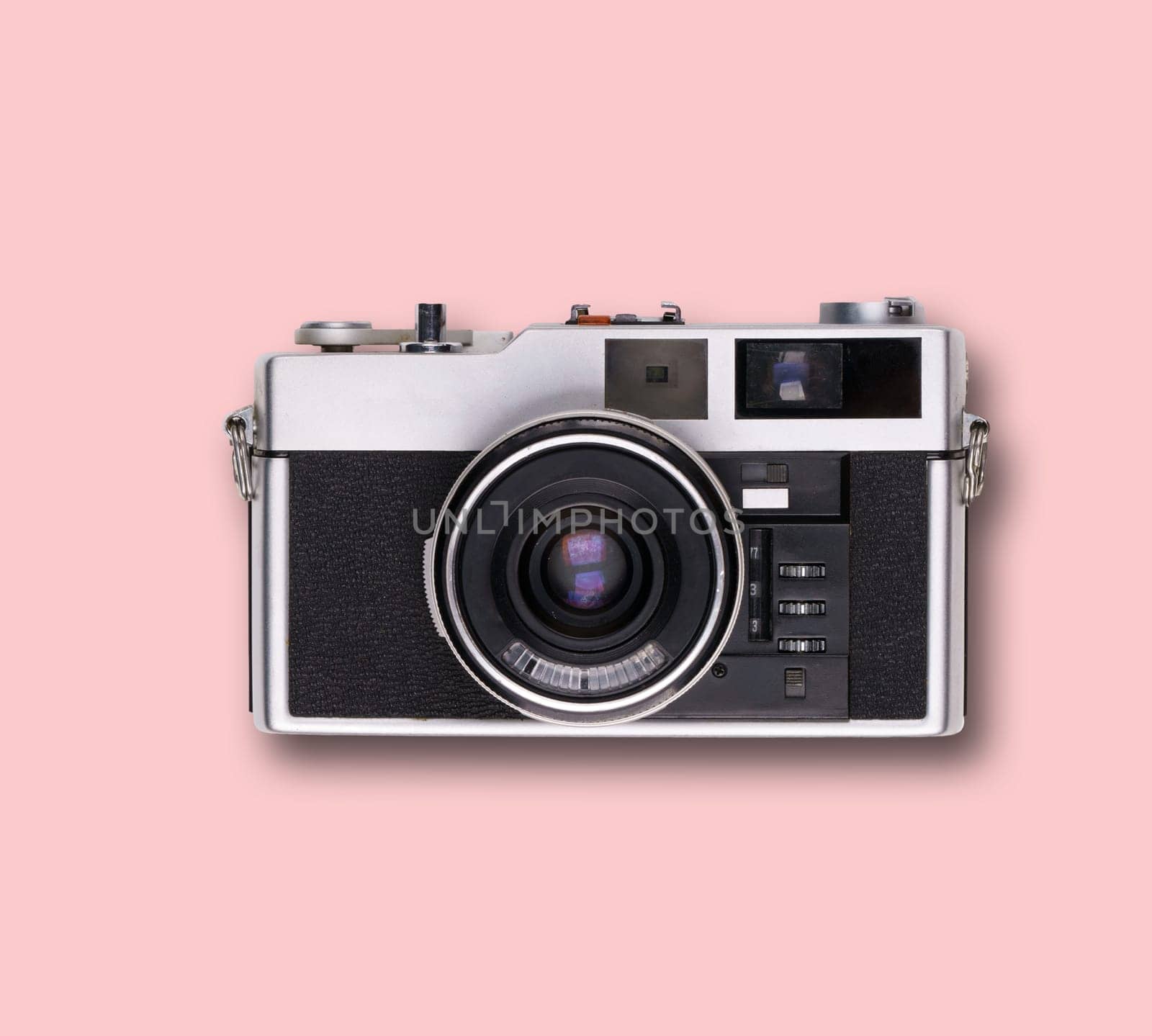 vintage old film camera on pink background with shadow