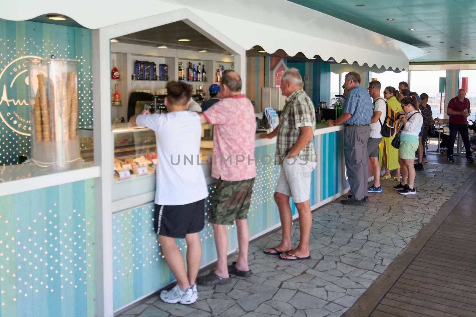 Catania, Italy -February 18, 2025: An ice cream shop with customers queuing at the counter. It is an outdoor terrace with a relaxed summer atmosphere. Concept: gastronomic experience, Italian culture.