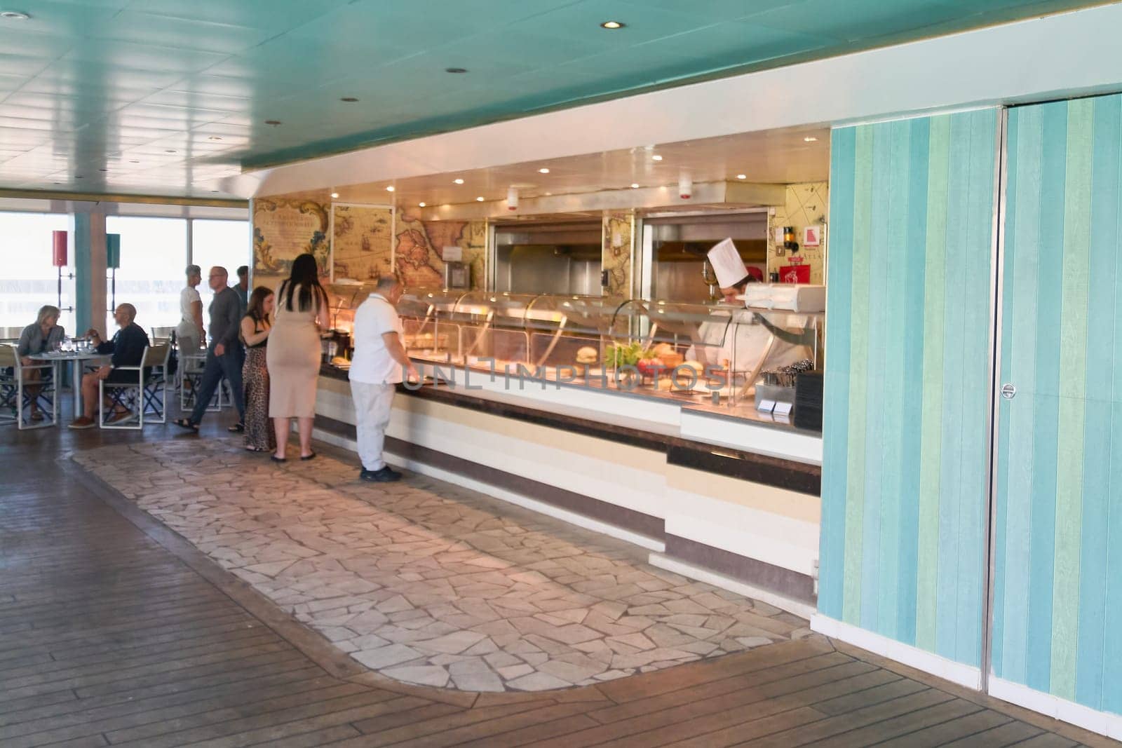 Catania, Italy - February 18, 2025: A self-service counter of a cafe displays sandwiches and fresh ingredients, and customers wait to choose their food. Concept: fast food, cafeteria service.