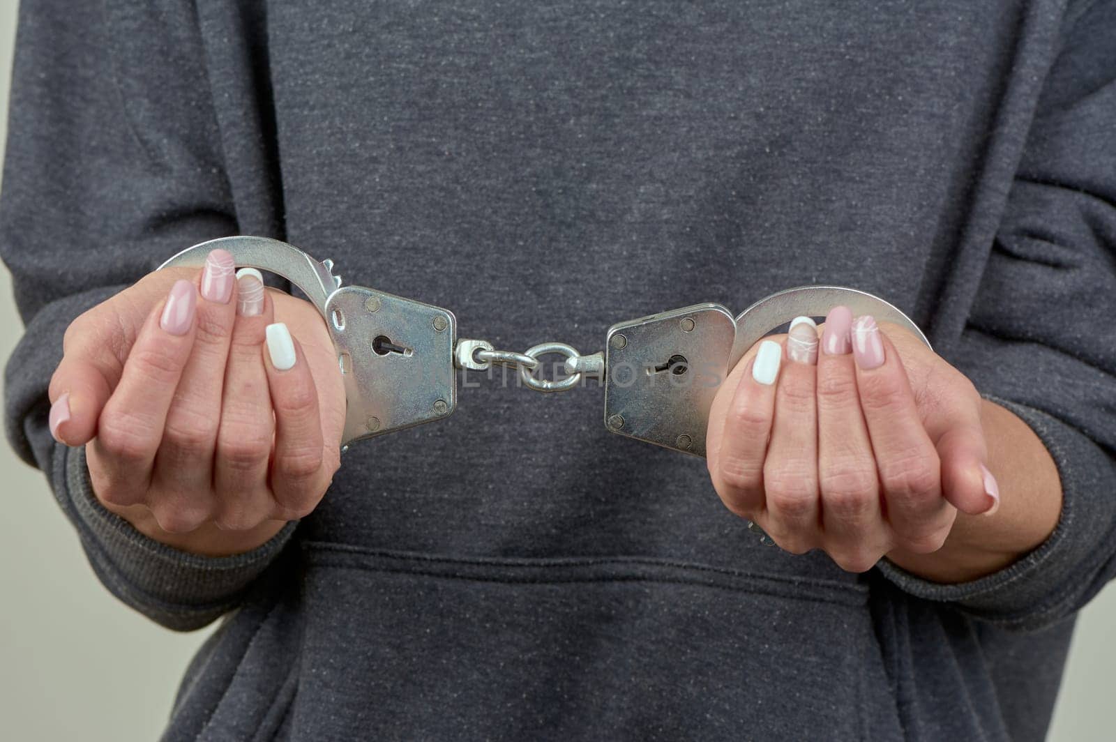 women's hands are handcuffed in close-up. High quality photo