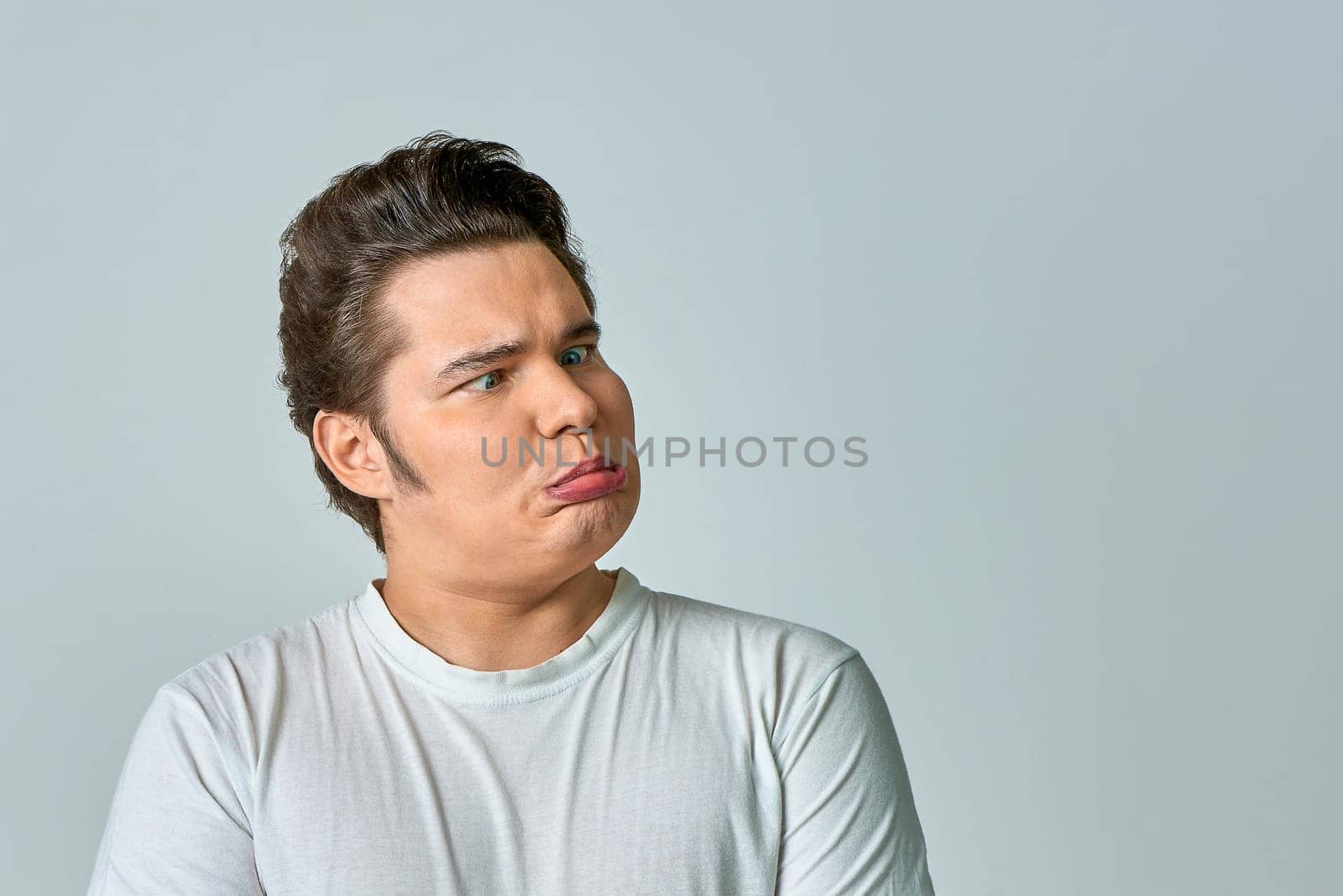 the man on the gray background brought his eyes together. High quality photo