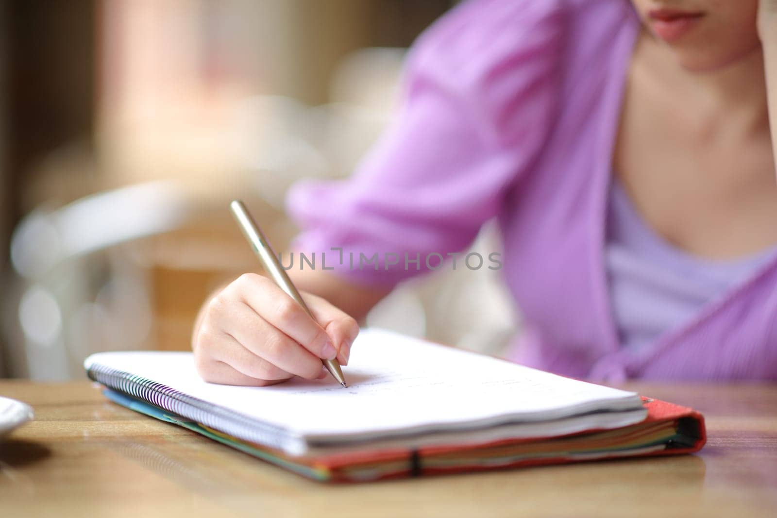 Close up portrait of a student writing notes in a bar terrace